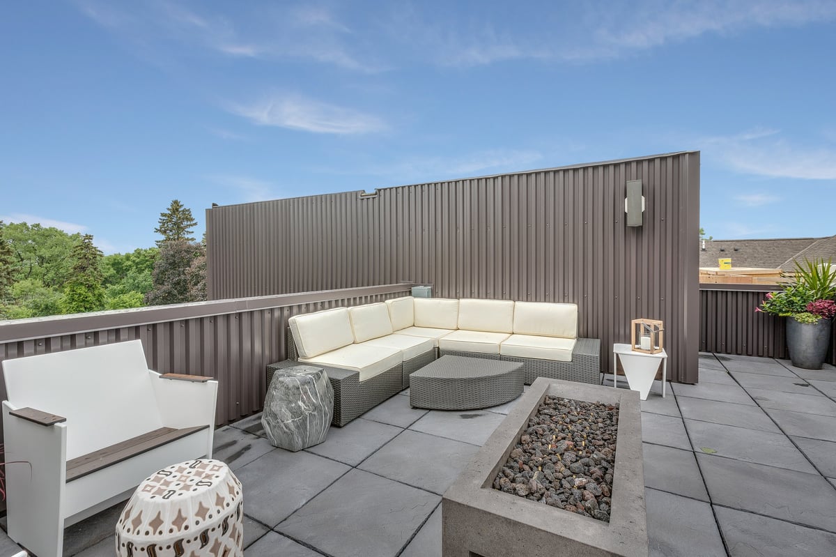 Rooftop acogedor con muebles de exterior, plantas y ambiente social en zona residencial