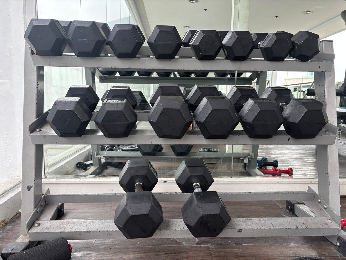 Rack de mancuernas hexagonales negras en gimnasio básico